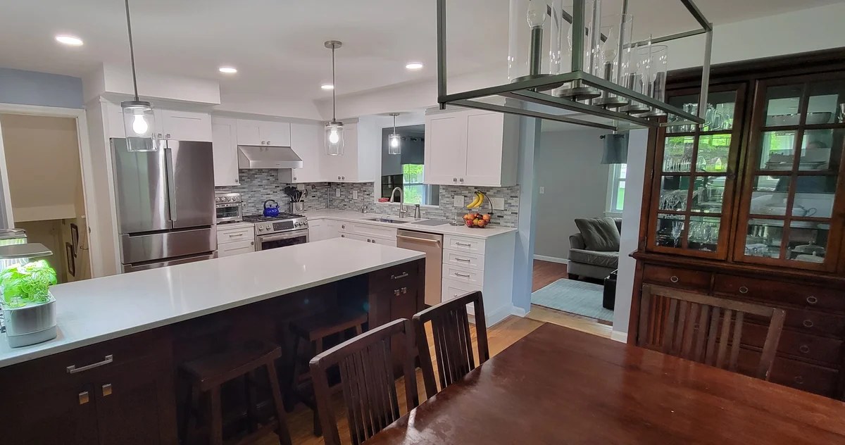 A completed Cabinet Coach kitchen with white cabinetry and a dark island