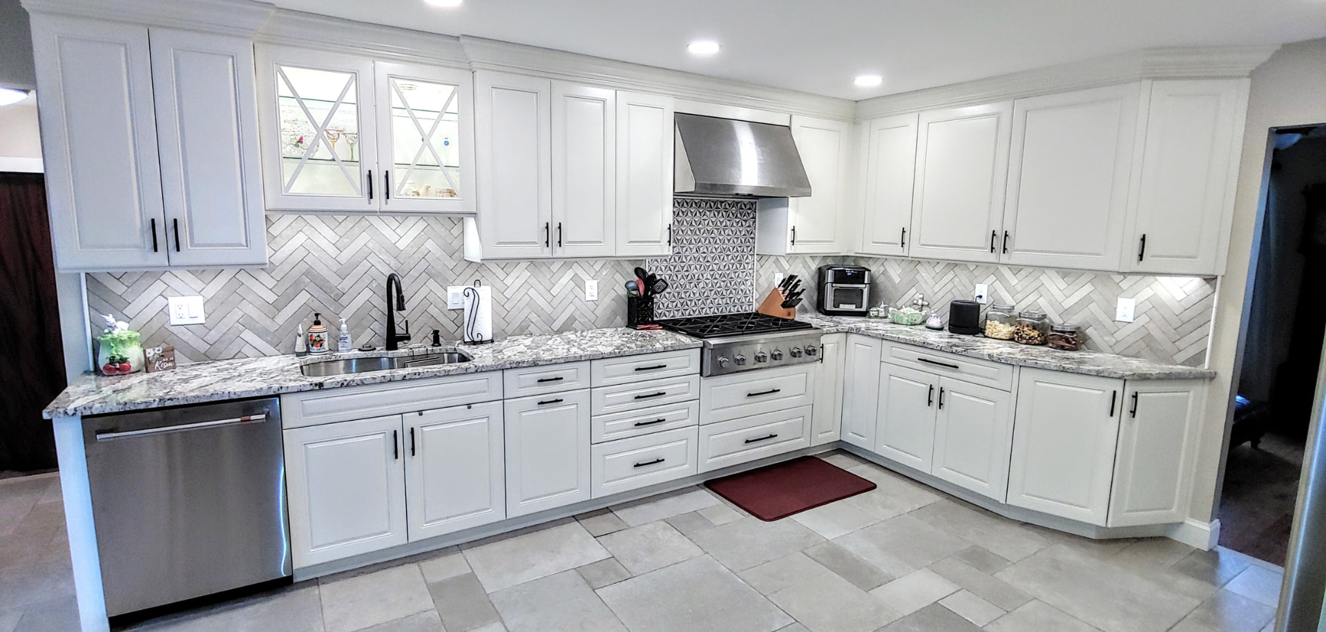 White shaker kitchen with herringbone backsplash cabinetry